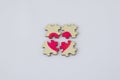 Broken puzzle with a painted pink heart on a white background Royalty Free Stock Photo