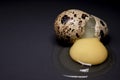 Broken Quail egg isolated on black background with leaking white and yolk. healthy raw food Royalty Free Stock Photo