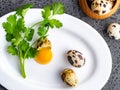 Broken quail eggs with parsley on the white table Royalty Free Stock Photo