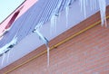 Broken Rain Gutters. Ice dam. Closeup on new broken rain gutter system without roof protection Snow guard on house construction.
