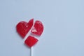 A broken red heart lollipop symbolizing a broken heart