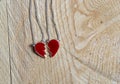 Broken red heart necklace on wooden background Royalty Free Stock Photo