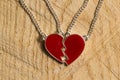 Broken red heart necklace on wooden background Royalty Free Stock Photo