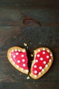 Broken red and white dotted heart shaped royal icing cookie on black background Royalty Free Stock Photo