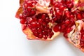 A broken ripe pomegranate fruit on a white background. juicy pomegranate berries Royalty Free Stock Photo
