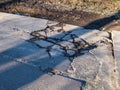 broken road with holes and protruding stones close-up, need for repair of the roadbed, bad road, abandoned