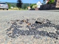 Broken road and repairs on a road with holes in the asphalt