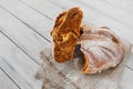 broken round grain fresh brown bread on a light wooden table  close up selective focus Royalty Free Stock Photo