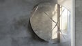 Broken Round Mirror on Concrete Wall Reflecting Sunlight Through Window in Minimalist Interior Royalty Free Stock Photo