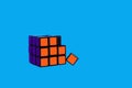 broken Rubik`s cube on a blue background, editorial