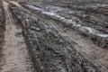 A broken rural country road after the rain. Puddles after rain on a dirt road. Clay, soil and puddles at cloudy day Royalty Free Stock Photo