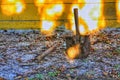 Broken shovel spade in the ground splotchy yellow wall