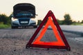 Broken silver luxury car emergency accident. Man driver installing red triangle stop sign on road. Sport automobile Royalty Free Stock Photo