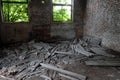 Broken slate sheets are lying on the floor of an abandoned building