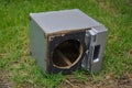 Broken speaker dumped on green grass Royalty Free Stock Photo