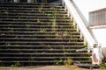 Broken stairs with special lifting platform for wheelchair users, at the entrance to abandoned building showing rust and decay