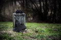 Broken stone cross, weathered gravestone on an old abandoned cemetery, concept for transience or gloomy halloween background with Royalty Free Stock Photo