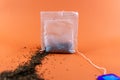 broken tea bag with orange background Royalty Free Stock Photo