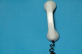 broken telephone receiver on wire weighs on blue isolated background, telephone receiver on prododi is broken Royalty Free Stock Photo