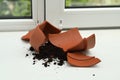 Broken terracotta flower pot with soil on windowsill indoors Royalty Free Stock Photo