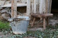 Broken tin bucket and an aluminum pot over the stool of the old Royalty Free Stock Photo