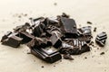 Broken to pieces dark chocolate, crushed and powder pieces Royalty Free Stock Photo