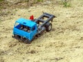 Broken toy car in the sand. Abandoned blue truck in the sandbox. photo Royalty Free Stock Photo