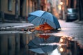 broken umbrella lying near a puddle on a rainy street Royalty Free Stock Photo