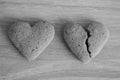 Broken and unbroken shortbread hearts on wooden background black and white as unhappy love background.