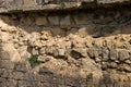 Broken wall of an old house nearby, traces of climate weathering. Cracked wall texture with hole. Brick stone wall of building Royalty Free Stock Photo