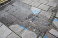 Broken water main in village street leaking water onto pavement Royalty Free Stock Photo