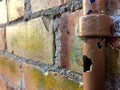 Broken water pipe on a brick wall