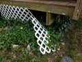 Broken white lattice fence on wood deck