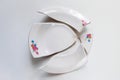 Broken white plate with flowers pattern on white background Royalty Free Stock Photo