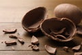 Broken and whole chocolate egg on wooden table, closeup Royalty Free Stock Photo