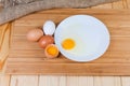 Broken and whole eggs on cutting board on rustic table Royalty Free Stock Photo