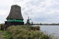 Broken Windmill and Traditional Old Green Windmills along the Zaan River in Zaanse Schans Netherlands