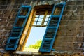 Broken window frame with blue shutter on a ruined house Royalty Free Stock Photo