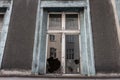 Broken window glass in abandoned old building. Dirty facade. Destruction concept. Vandalism concept. Grunge architecture exterior.