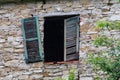 Broken window with green wooden shutter in a stone wall l of an Royalty Free Stock Photo