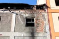 Broken window with old rustic dilapidated wooden frame and growing plants on abandoned factory building wall Royalty Free Stock Photo