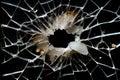 Broken window pane with shattered glass and circular hole, displaying extensive damage Royalty Free Stock Photo