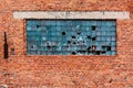 Broken windows in on old red brick building on the grounds of an abandoned factory Royalty Free Stock Photo