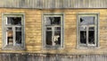 Broken windows in an old wooden ruined house, barrack, ruins