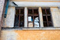 Broken windows with wooden frames in an abandoned yellow building close Royalty Free Stock Photo