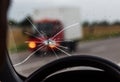 Broken windshield of a car. A web of radial splits, cracks on the triplex windshield. Broken car windshield, damaged glass with