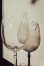 Broken wineglass in sunlight on wooden background. Damaged wine glass with sharp edges. Cracked glass in shadows Royalty Free Stock Photo