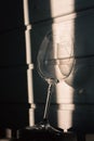 Broken wineglass in sunlight on wooden background. Damaged wine glass with sharp edges. Cracked glass in shadows Royalty Free Stock Photo