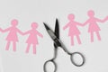 Broken women paper chain with scissors on white background - Bro Royalty Free Stock Photo