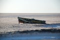 Broken wooden boat on the shore of a salt lake